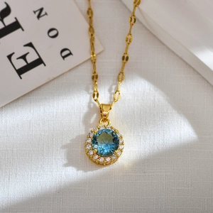 Detailed close-up of a gold necklace with a blue round gemstone surrounded by diamonds