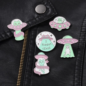 Broches en émail chat extraterrestre et OVNI sur le revers d'une veste en cuir noir