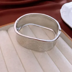 Minimalist silver hammered textured wide cuff bracelet with a modern rock pattern finish