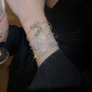 Macro detail of silver bangles set featuring heart and square cubic zirconia stones