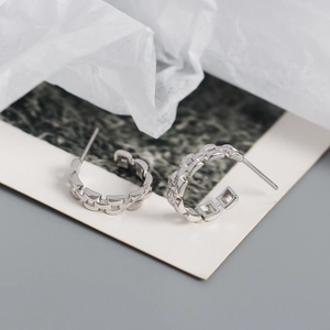 Close-up of S925 silver C-shaped earrings with a unique geometric chain texture design