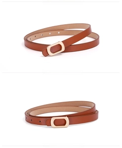Detail view of women's thin caramel PU leather belt with a light gold rectangular buckle