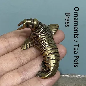 Detalle de una figura de morsa de latón macizo vintage sostenida para mostrar el tamaño
