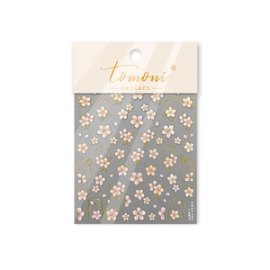 Close-up of pink cherry blossom nail art stickers with metallic gold accents and shell luster