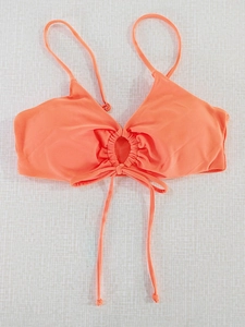 Detail of coral orange bikini top with center ring, ruching and long adjustable ties