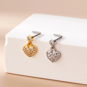 Macro detail of L-shaped nose studs with micro-paved zircon heart charms in gold and silver