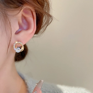Close-up of elegant gold plated hollow hoop earrings with sparkling cubic zirconia inlay