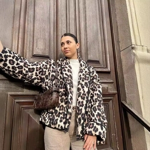 Women's leopard print quilted jacket styled with casual trousers and a vintage handbag