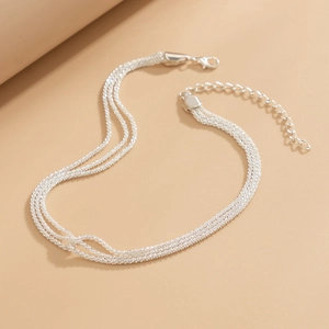 Close-up of silver multilayer snake chain necklace with lobster clasp and extender