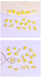 Flat lay of yellow acrylic DIY cat-themed jewelry charms in paw and heart shapes