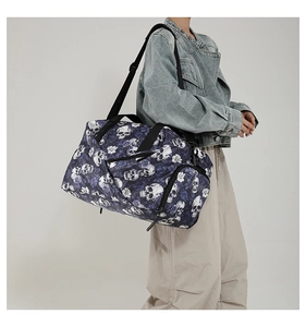 Deep blue fitness travel bag featuring white skull and floral prints with adjustable strap