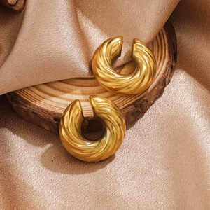 Detailed view of gold plated croissant dome hoop earrings with twisted texture details