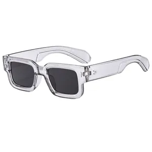 Modern square sun glasses with transparent gray frame and dark lenses with rivets