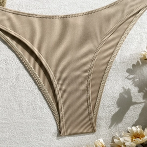 Detail shot of ribbed khaki bikini bottom with fine stitching and soft shadow lighting