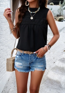 Detail of black sleeveless top featuring elegant lace stitching and polka dot texture