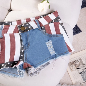 Pantaloncini di denim a vita bassa con stampa bandiera americana, strappi e orli sfilacciati