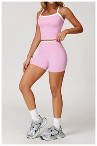 Λεπτομέρεια από ροζ σορτς γιόγκα και crop top με λευκές λεπτομέρειες σε αντίθεση για άσκηση
