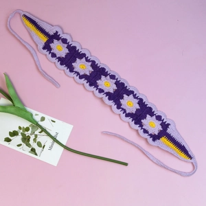 Detail of handmade crochet headband featuring purple floral patterns and yellow accents