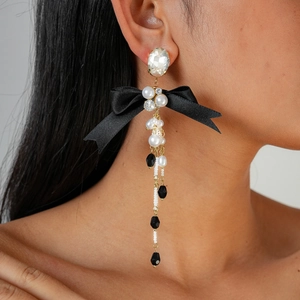 Elegant bow tassel earrings with rhinestones and pearls on model for a vintage aesthetic