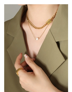 Detail of layered gold chunky chain necklace with freshwater pearl and engraved plate