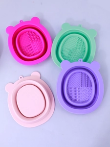 Macro detail of four silicone bear-shaped makeup brush cleaning mats with varied textures
