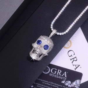 Macro detail of silver skull pendant with blue eyes and white moissanite on tennis chain