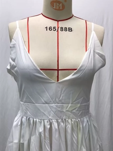 Detail of white V-neck pleated maxi dress showing waist design and silky satin texture