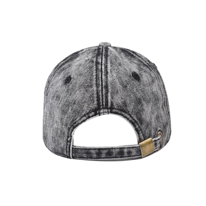 Detail of washed denim baseball cap back featuring adjustable metal buckle and distressed texture