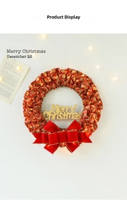Detail of Christmas wreath with red fabric, gold Merry Christmas sign and warm LED lights