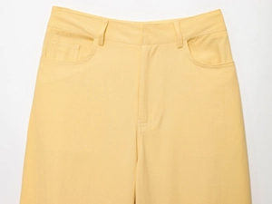 Gros plan détaillé de la taille d'un pantalon large jaune montrant la texture du sergé