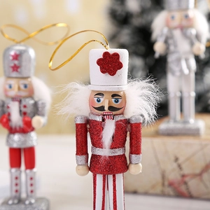 Detail of a red wooden Nutcracker ornament with sequins, stripes and gold hanging string