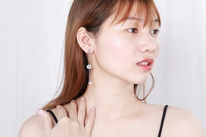 Macro shot of silver tassel earrings with transparent zircons worn by a model