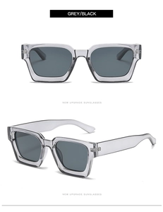 Detalle de gafas de sol cuadradas en gris translúcido con patillas anchas y lentes oscuras