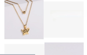 Detail of gold-plated double-layer necklace with hollow butterfly and bead charms