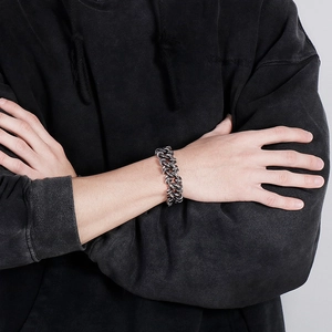 Close-up of bold silver stainless steel thick curb chain bracelet on a male model