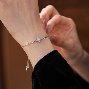 Close-up of adjustable silver star and cross bracelet with cubic zirconia on wrist