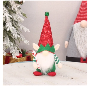 Close-up of a Christmas gnome doll with red sequin hat holding a candy cane decoration