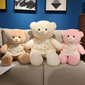Ours en peluche rose et marron portant des robes à cœurs en dentelle sur un canapé