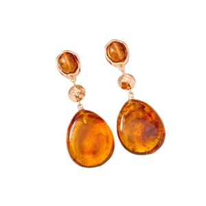 Vintage amber resin teardrop pendant earrings with gold metal frame on white background