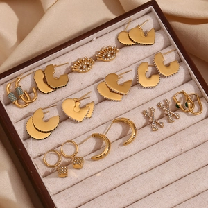 Detailed macro view of 18K gold plated C-shaped geometric earrings set on a silk tray
