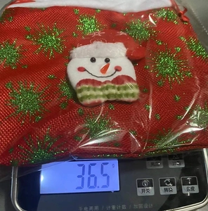 Detail view of 3D snowman Christmas gift bag with glitter snowflakes, weight 36.5g shown