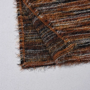 Detailed macro shot of the warm orange knit fabric texture and high-quality edge stitching
