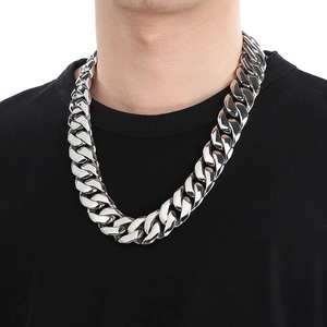 Close-up of 24mm silver titanium steel Cuban chain necklace worn by a male model