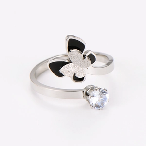 Detailed macro view of silver stainless steel butterfly ring with oil-dripping enamel detail