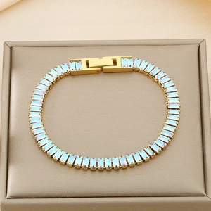 Detailed close-up of a gold titanium bracelet with iridescent zircon on a jewelry box