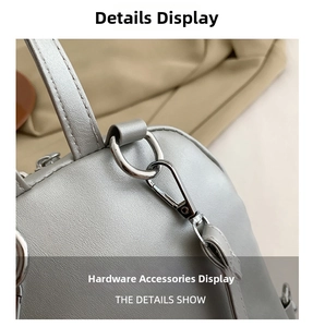 Close-up of silver D-ring and lobster clasp on gray lychee grain PU leather bag