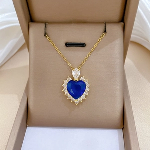 Close-up of a heart-shaped blue zircon necklace in a brown luxury jewelry gift box