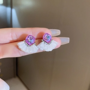 Detail view of ethnic fringe earrings with purple crystal and white pleated fan charms