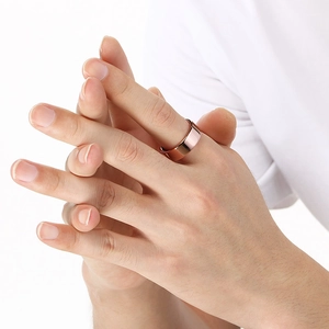 Detailed view of 8mm rose gold tungsten ring worn on finger with polished finish