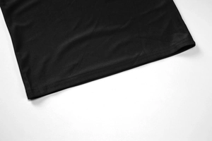 Détail en gros plan des doubles coutures sur l'ourlet d'une robe moulante noire